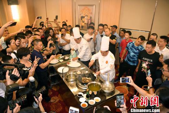 闽菜大师强木根首徒陈依宇与闽菜大师强曲曲首徒姚建明联袂合作表演烹饪经典闽菜“爆炒双脆”,吸引众人围观。 记者刘可耕 摄