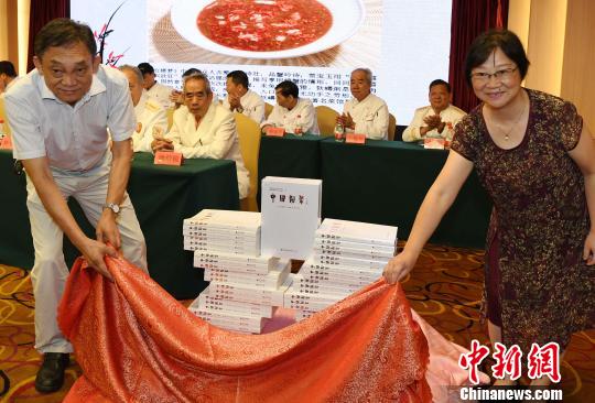 福建省闽菜技艺研究会会长强振涛(左),福建人民出版社副社长曹希莎(右)共同为《中国闽菜》正式出版“掀起盖头来”。 记者刘可耕 摄